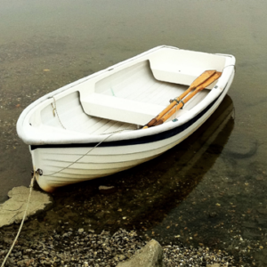An empty rowboat floats on water.
