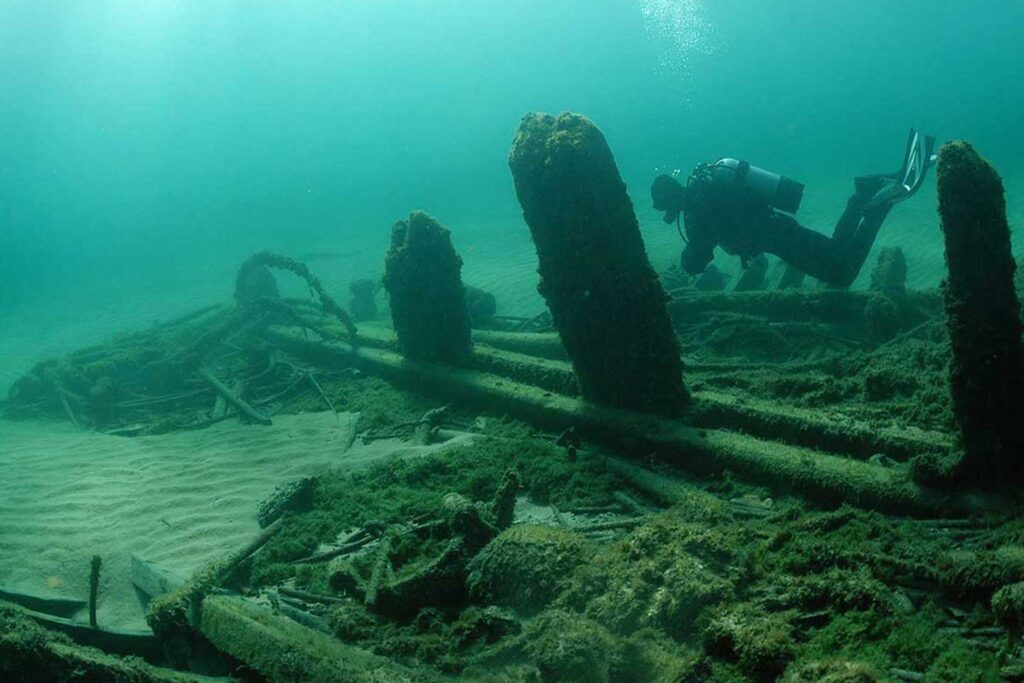 A diver swims along the keelson of a shipwreck at the bottom of Lake Michigan. (Photo by Tamara Thomsen / Wisconsin Historical Society)